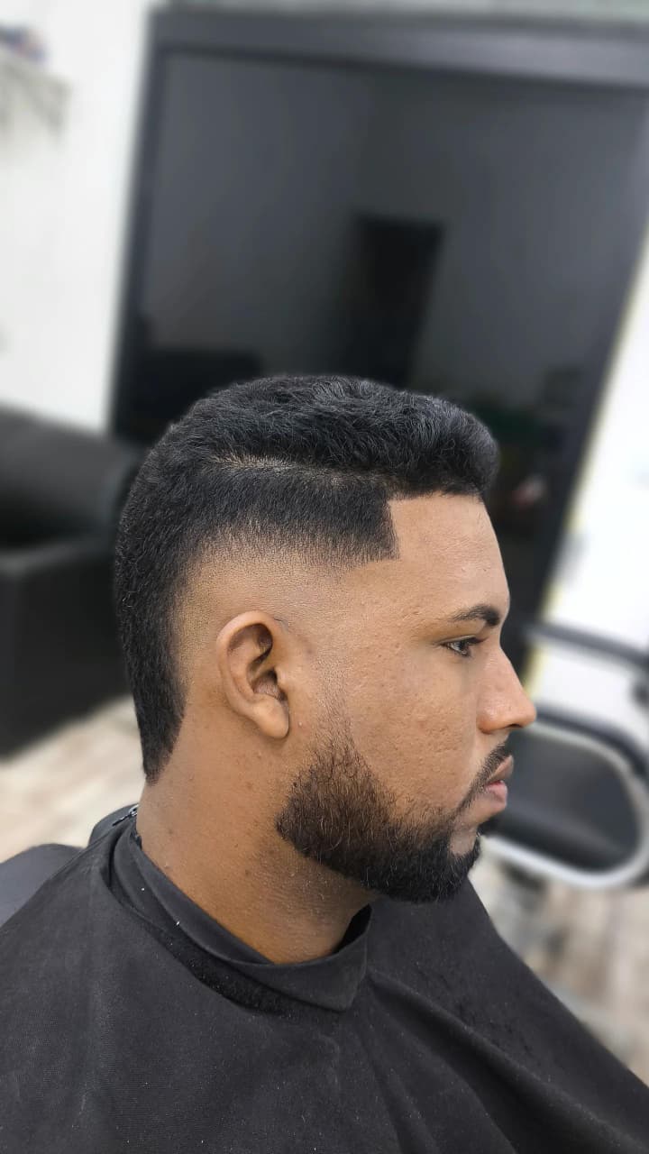 Corte masculino com degradê, linha lateral e barba alinhada